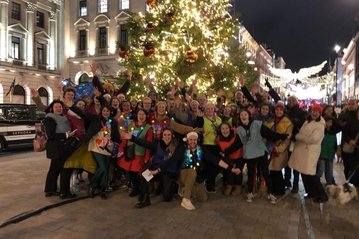 a group of people standing in front of a crowd posing for the camera